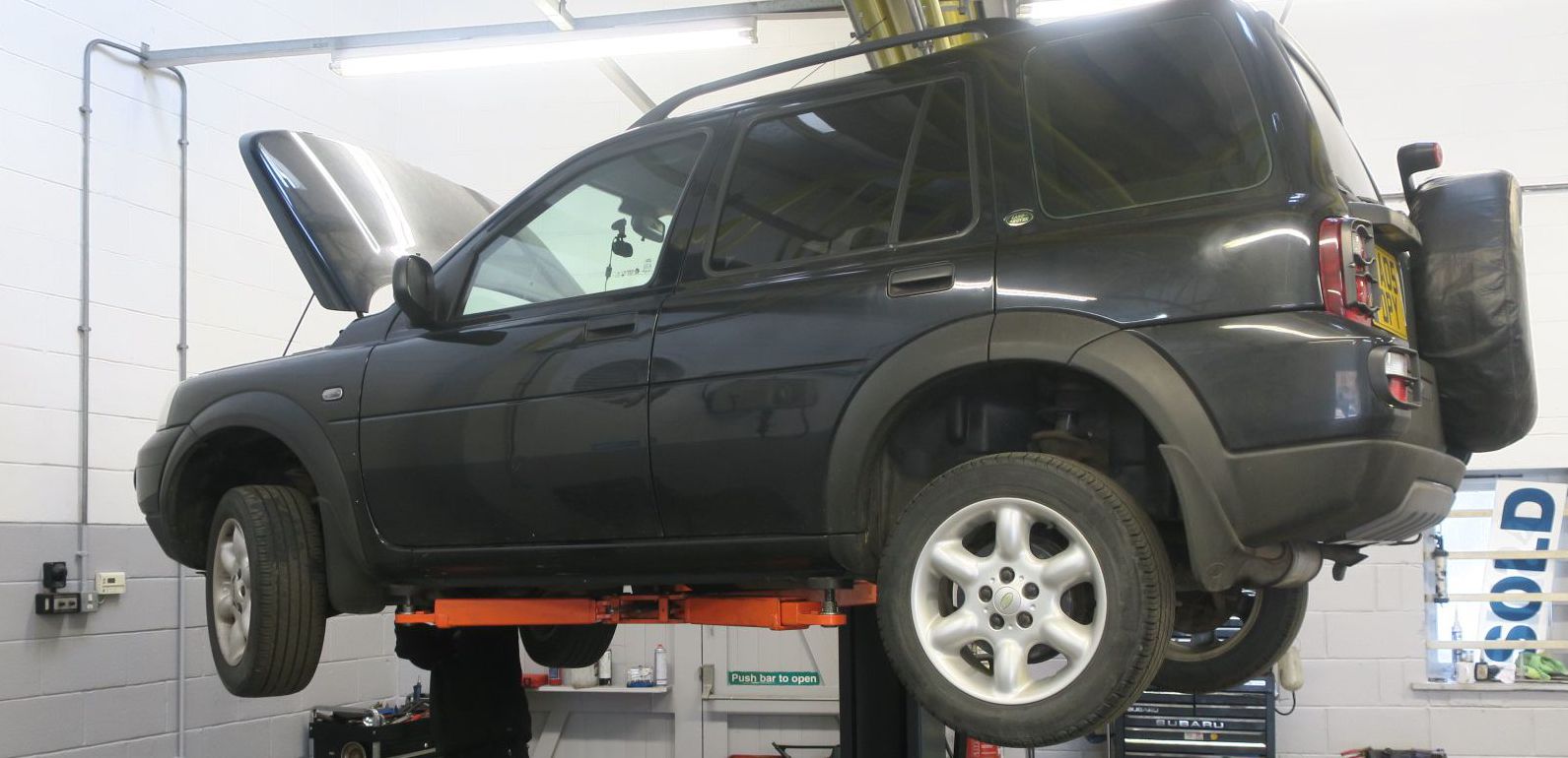 A vehicle on the lift inside the Glovers workshop